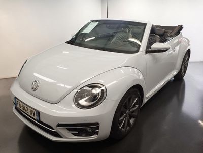 La Volkswagen Coccinelle décapotable est garée dans un showroom, le toit rabattu.