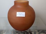 a brown vase with a sticker on it sitting on a table