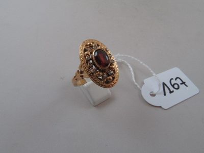 a close up of a gold ring with a red stone on it