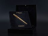 un stylo doré dans une boîte noire sur fond noir