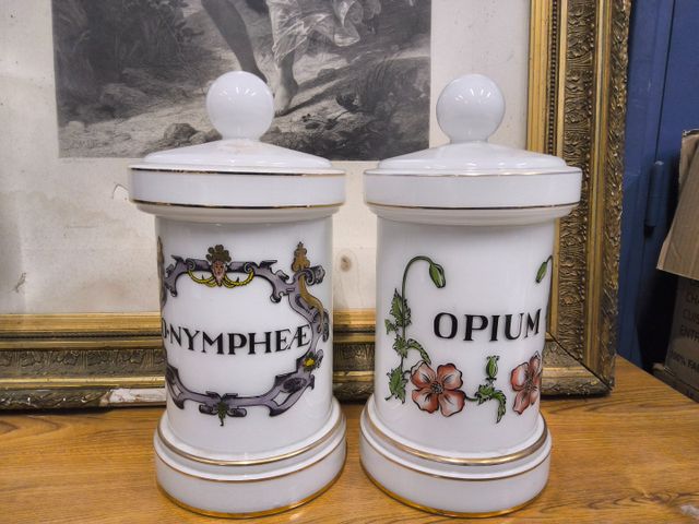 Deux pots à pharmacie en verre teinté blanc à décor de filets dor...