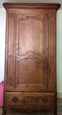 une grande armoire en bois dans le coin d'une pièce