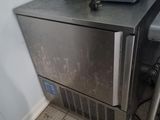 un petit réfrigérateur argenté posé dans un coin de la cuisine