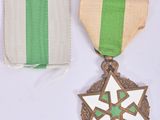 two medals and a ribbon on a white surface