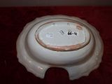 a white bowl with a gold rim on a red table