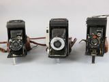 three old cameras sitting next to each other on a table