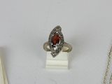a silver ring with a red stone on top of it