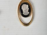a gold ring with a black and white cameo on it