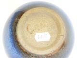 a close up of a blue vase with a tag on it