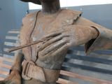 a statue of a man holding a cigarette in one hand and a cigarette in the other