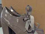 grey high heeled shoes with a bow tied around the toe