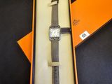une boîte orange contenant une montre, posée sur une table