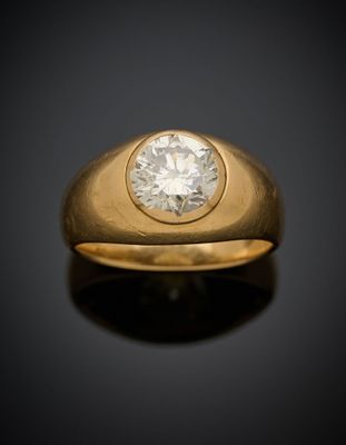 gros plan d'une bague en or avec un diamant au centre