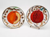 deux assiettes ornées de fruits, posées sur une surface blanche