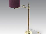 une lampe de table en laiton surmontée d'un abat-jour violet