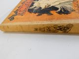 un vieux livre posé sur une table sur une surface blanche