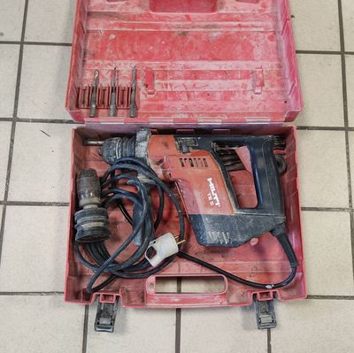 a red tool box with tools in it on a tiled floor