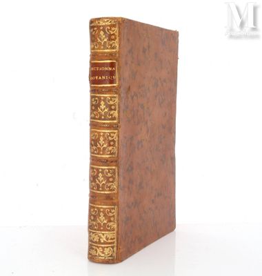 un vieux livre posé sur une table blanche à côté d'un mur blanc
