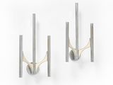 a pair of metal wall mounted hooks on a white wall