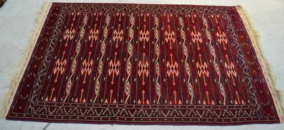 un tapis rouge posé sur un lit recouvert d'une couette blanche