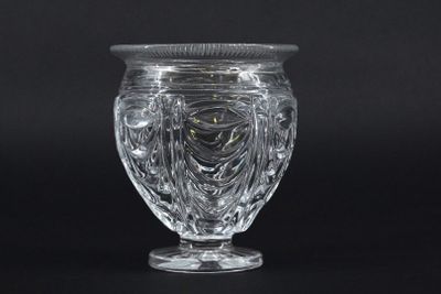 a clear glass vase with a lid on a black background