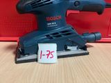 une ponceuse orbitale Bosch posée sur une table, avec son étiquette de prix