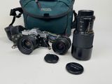 un appareil photo, un objectif, un étui pour appareil photo et un appareil photo posé sur une table