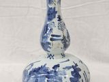 a blue and white vase sitting on a white surface