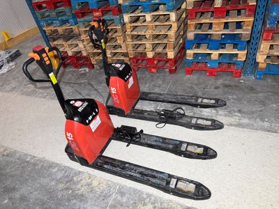 two forklifts sitting next to each other in a warehouse