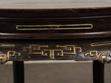 a wooden table with a black and gold design on it