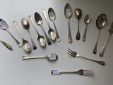 a lot of silver spoons and forks on the table