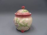 un petit pot muni d'un couvercle orné de fleurs