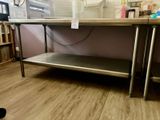 une table sur laquelle est posée une étagère en métal, dans une pièce