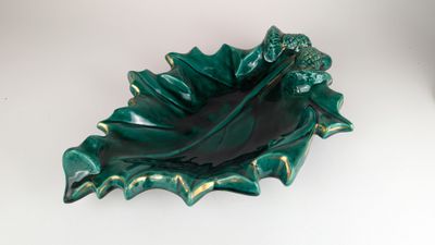 un bol vert en forme de feuille posé sur une table blanche