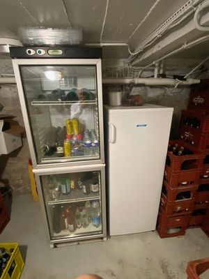 a refrigerator and freezer in the basement of a house