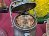 une casserole avec un couvercle posée sur une table à côté d'autres objets en verre