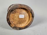 a small wooden vase with a label on it