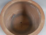 a large brown pot sitting on a white surface