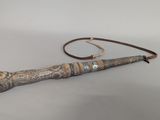 an old wooden stick with a metal handle on a white surface