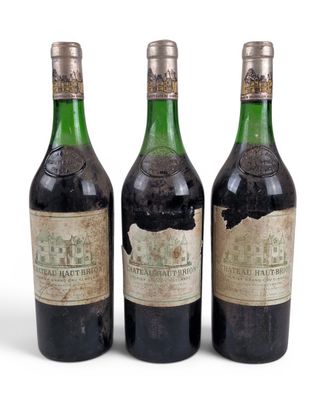 trois bouteilles de vin posées les unes à côté des autres sur une surface blanche