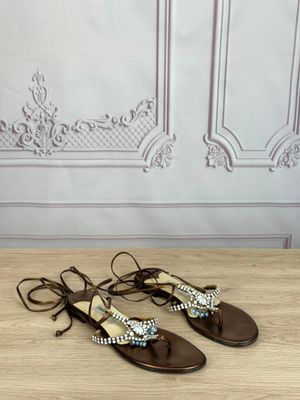 a pair of women ' s sandals on a wooden table in front of a wall