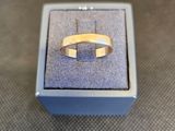 une bague en or posée dans une boîte bleue sur une table