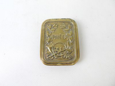 a small gold plate with a skull and crossbone on it