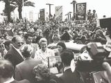 photo en noir et blanc montrant une foule et un homme dans une voiture