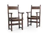 pair of antique wooden chairs with carved arms on white background