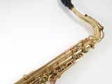 a close up of a saxophone on a white surface