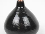 a black vase that is sitting on a white surface