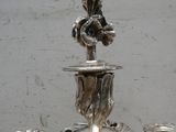 trois bougeoirs en argent posés les uns à côté des autres sur une table
