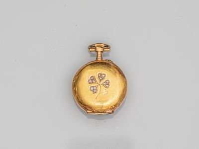 a close up of a gold pocket watch on a white surface