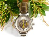 a close up of a watch on a table with flowers